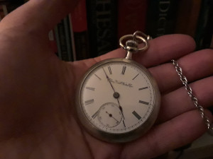 Image of a hand holding an antique pocket watch